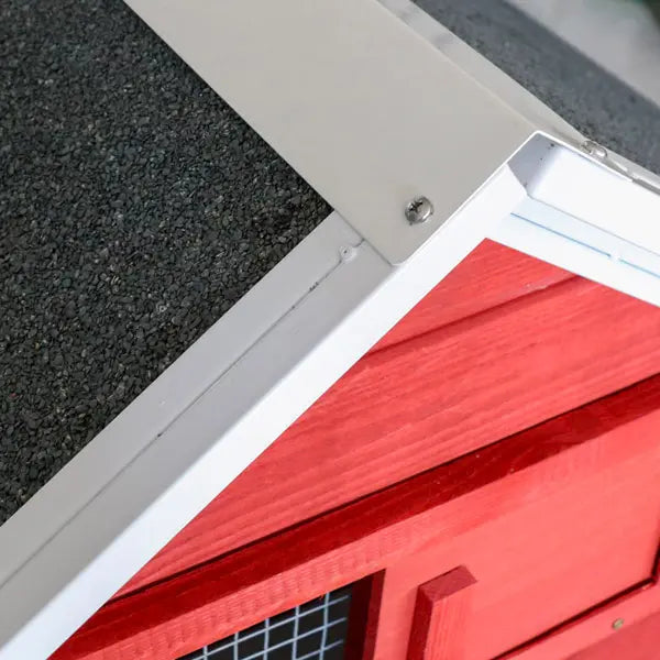 Close-up of a red metal gate with a white frame on a textured surface.