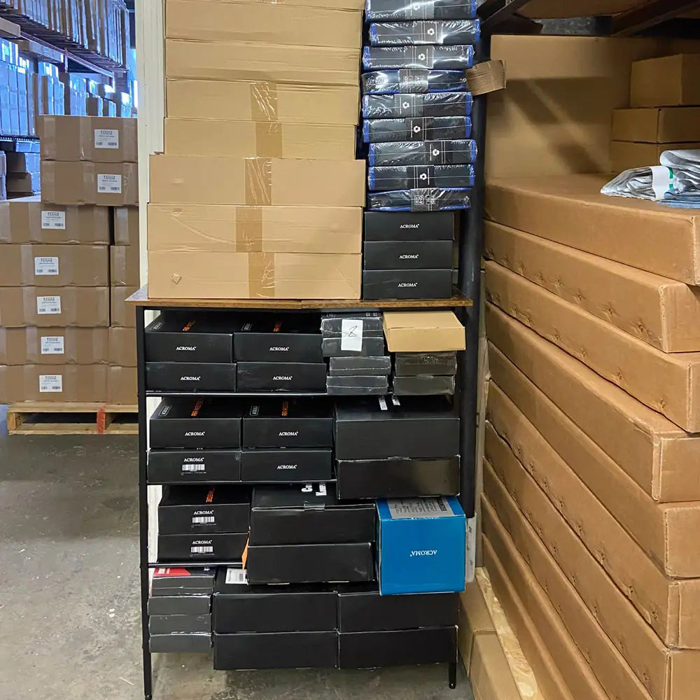 Stacks of boxes in a warehouse setting with a focus on black and brown packaging.