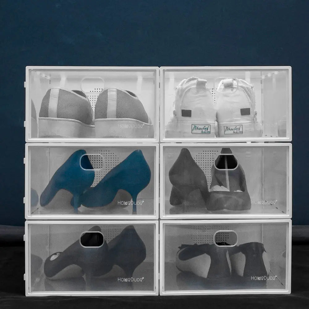 Clear shoe storage boxes with various shoes inside on a dark background