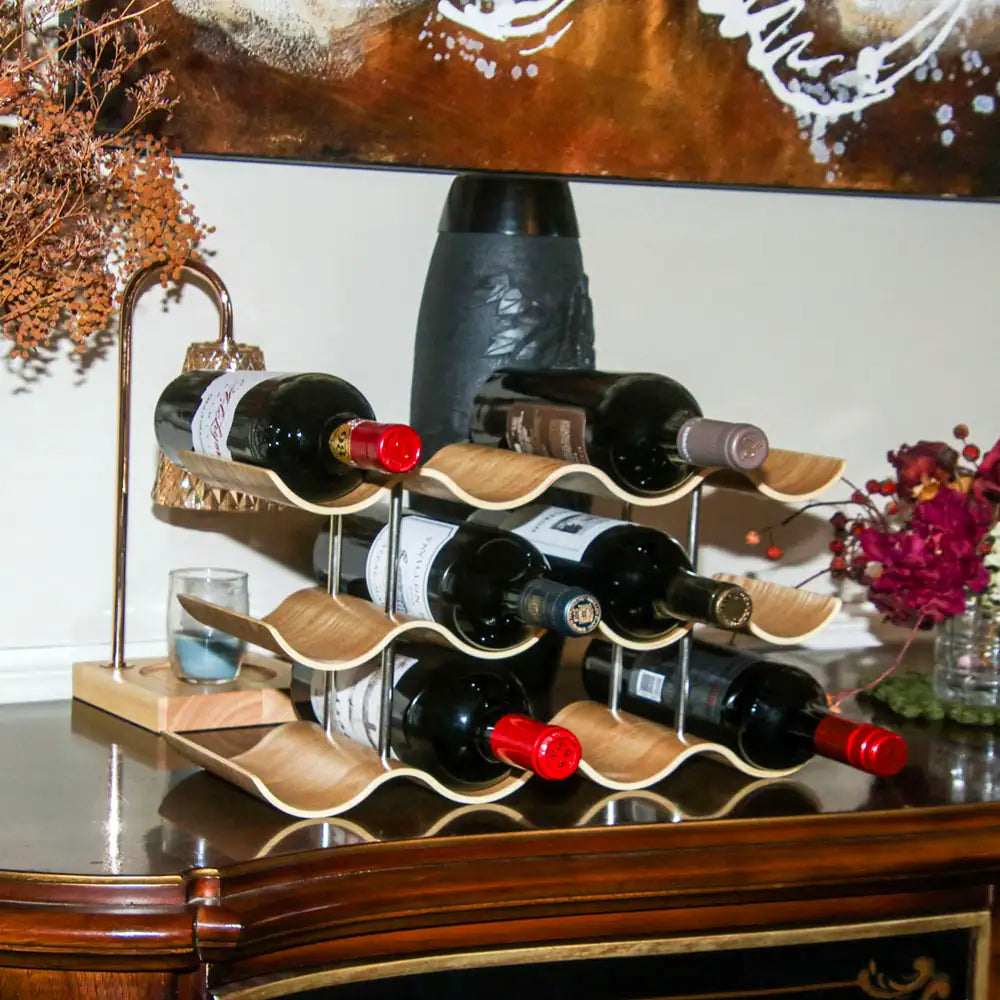 Wooden wine rack with bottles on a reflective surface, decorative elements in the background