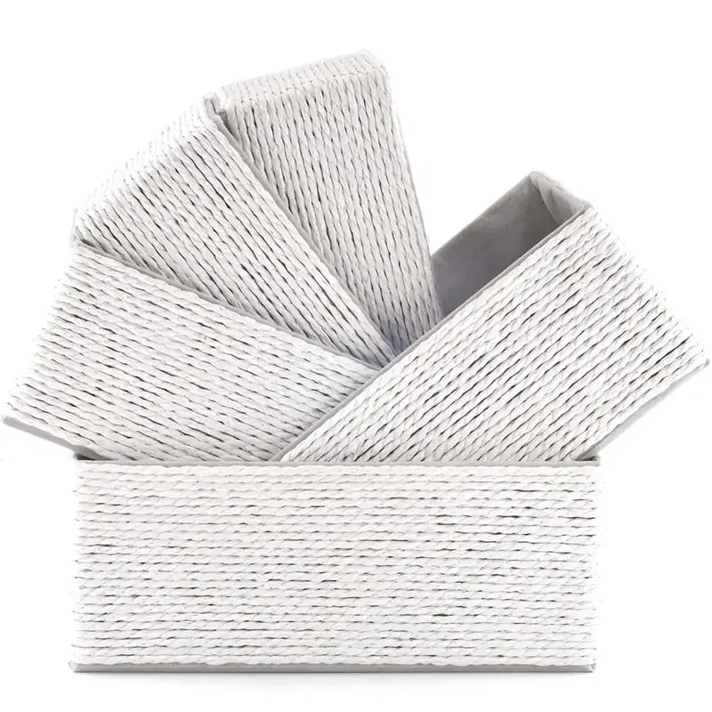 Five Creamy white-colored woven paper rope baskets stacked diagonally inside each other