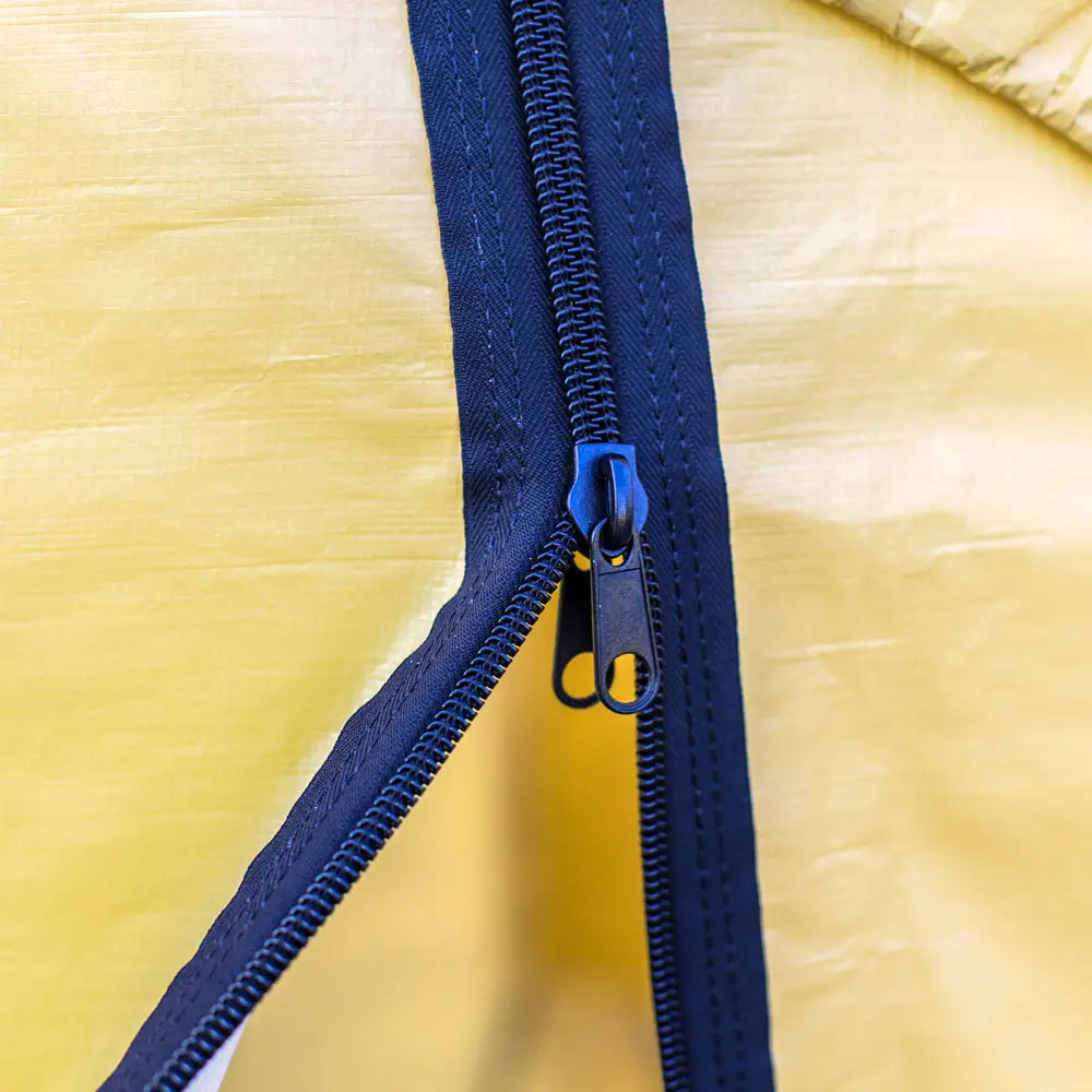 Close-up of a blue zipper on a yellow background