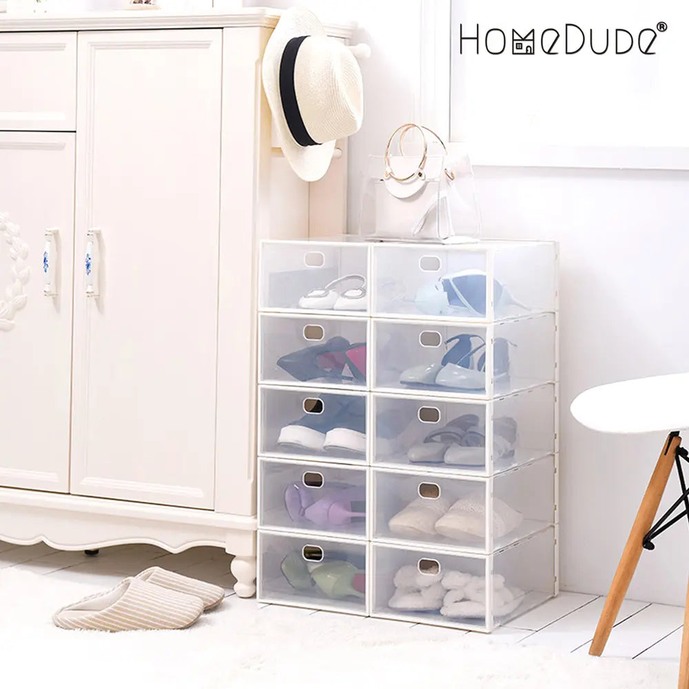 Clear shoe boxes with shoes inside, placed against a white wall with 'HomeDude' branding.