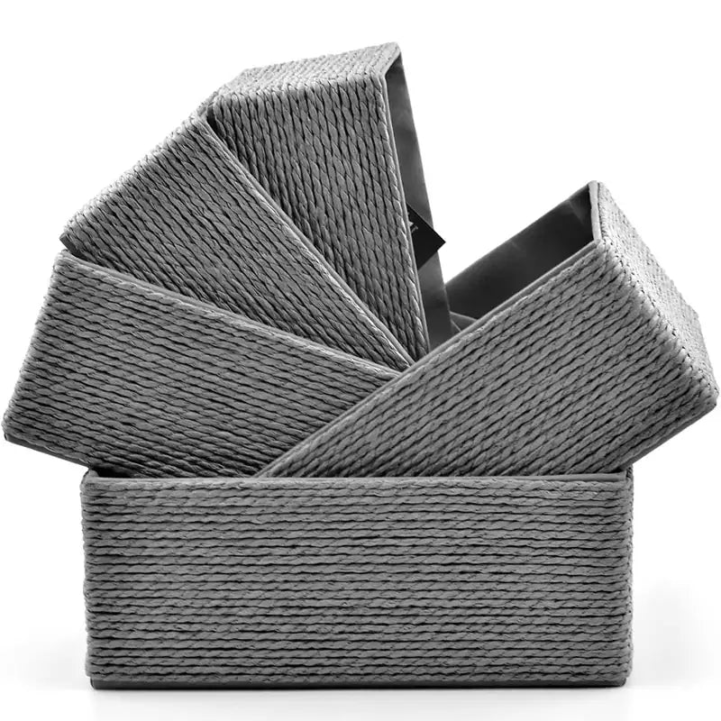Five grey-colored woven paper rope baskets stacked diagonally inside each other